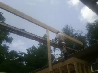 Carpenter setting a ridge beam over a new addition frame — Ice Dam Removal by Roofing Brothers in Bullville