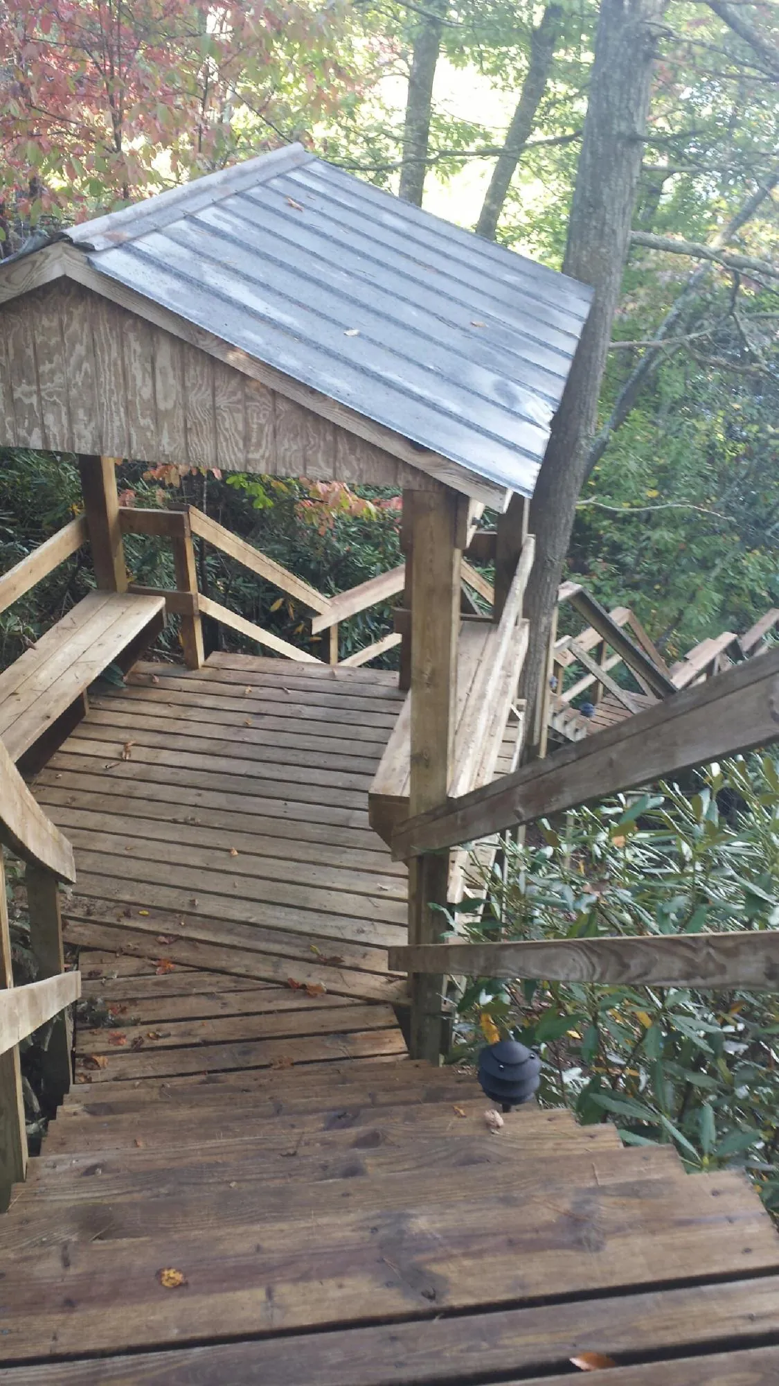 Metal roofed shelter over wooden steps on a wooded walkway — Skylight Repair & Installation work by our crew in Bullville